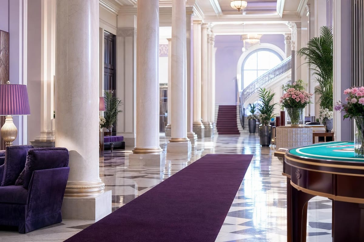Großes Foyer eines klassischen Kurhaus-Casinos mit Marmorboden, Säulen und pflaumenfarbenem Teppichläufer, leer (mit AI erstelltes Bild)